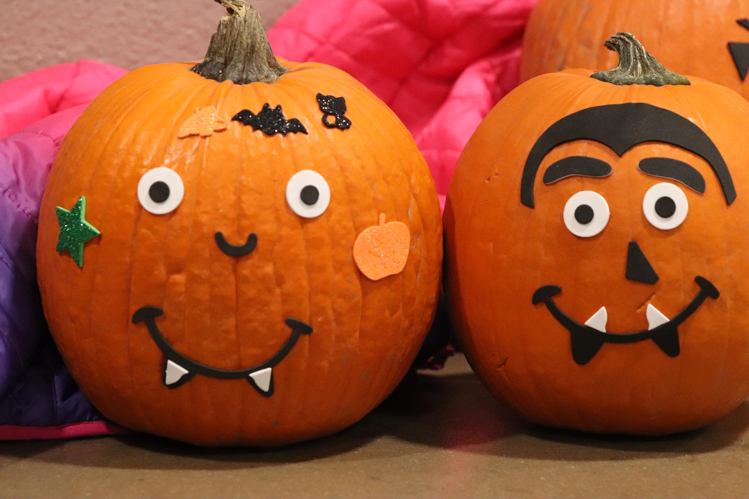 Two pumpkins decorated with foam faces